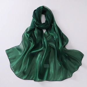 Detail of dark green organza scarf showing luxurious glossy texture and fine hem edges