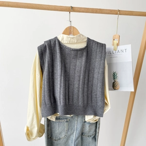 Detail shot of grey knitted shawl texture with cream shirt and denim pants outfit