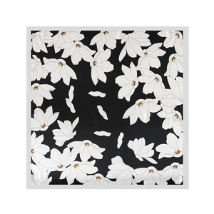 Detail of elegant black satin square scarf featuring white floral magnolia print patterns
