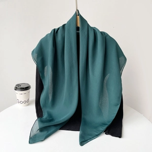 Detail of dark green lightweight chiffon scarf with a smooth drape and soft texture