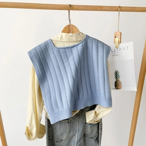 Detail of light blue knit vest with vertical hollow stripes over a yellow shirt