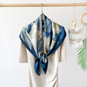 Detail of elegant navy blue square scarf with large floral print draped on a dress