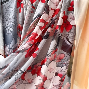 Détail d'une écharpe en soie avec motifs de fleurs rouges et blanches sur mousseline