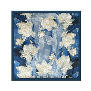 Flat lay of 90cm square silk scarf with floral print and gold outlines on blue background