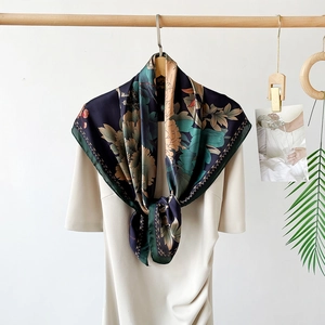 Detailed view of dark blue silk-like scarf with vintage floral peony pattern and green border