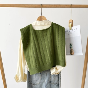 Close-up of vintage green hollow-out knit vest layered over a beige collar shirt