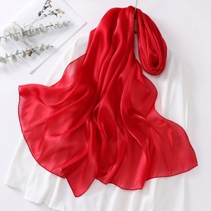 Detail view of glossy red organza scarf with lightweight texture and refined rolled edges