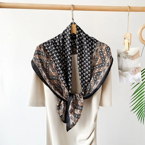 Detail of a 90cm square satin silk scarf with vintage paisley pattern on a beige dress