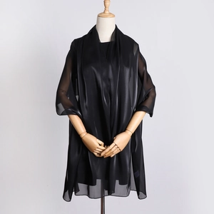 Detailed view of black organza headscarf showing sheer glossy texture and elegant drape