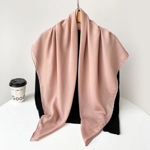 Detail of light pink chiffon headscarf with fine edge stitching on wooden hanger