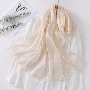 Detail of elegant champagne organza scarf with smooth glossy finish and fine hemmed edges