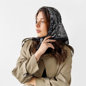 Detail view of black and white paisley satin scarf worn as a stylish headwrap