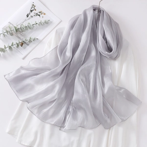 Detail of elegant silver grey organza scarf with glossy texture and fine edge stitching