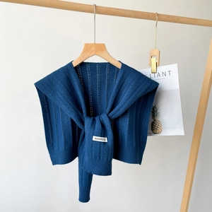 Detailed macro view of the dark blue knitted shawl featuring hollow vertical stripe textures