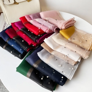 Détail de foulards légers avec ornements de perles élégants et bords dorés métallisés