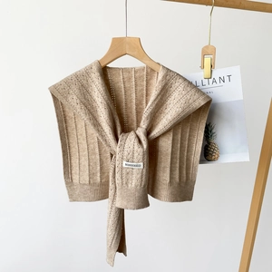 Detail of beige knitted shawl with vertical ribbed texture and hollow out pattern design