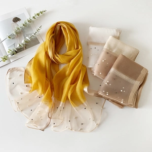 Détail de foulards en soie de couleur unie avec dentelle transparente et perles fines