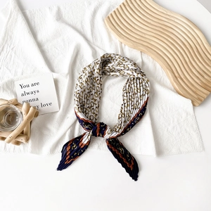 Close-up of pleated silk scarf featuring nautical chain print and elegant color blocking