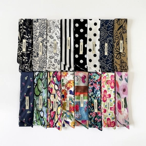 Flache Darstellung verschiedener Baumwoll-Skinny-Schals mit Blumen- und Punktmustern