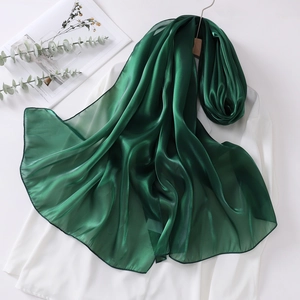Detail of dark green organza headscarf showing translucent texture and soft sheen