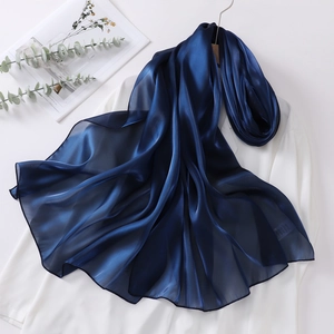Macro view of navy blue organza headscarf showing glossy silk-like texture and soft drape