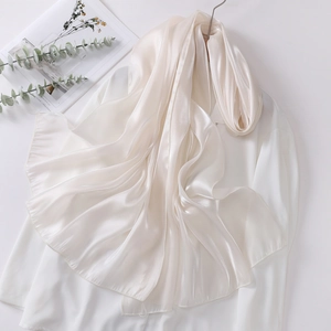 Detail view of pearl white organza headscarf with premium silk gloss draped on shirt