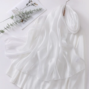 Detail of white organza headscarf with satin sheen draped over a classic white shirt