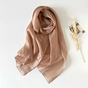 Detailed view of the champagne organza scarf with subtle pearlescent finish and edge stitching