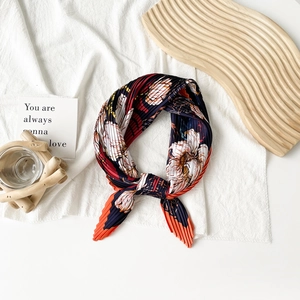 Detailed view of pleated silk scarf with floral print on dark blue satin fabric