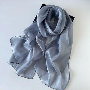 Macro detail of elegant silver-blue organza silk scarf with premium glossy texture