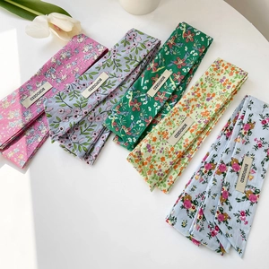 Detailansicht von fünf doppellagigen Baumwollschals mit Blumenmustern und Webetiketten