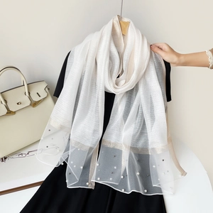 Détail de l'écharpe transparente blanche avec bordure dorée champagne et perles délicates