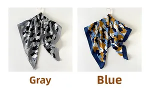 Detail view of two twill silk square scarves with blue and grey camouflage cloud prints