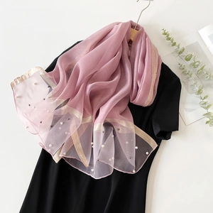 Détail d'un châle en soie violet clair avec perles délicates et bordures dorées