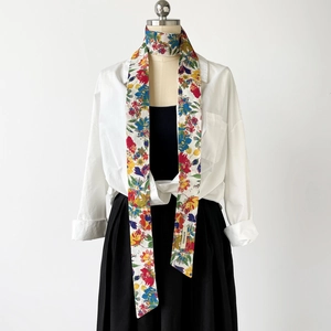 Baumwoll-Twilly-Schal mit Blumendruck, als stilvolles dekoratives Accessoire gebunden