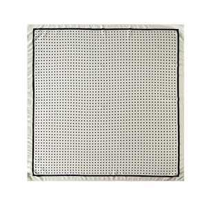 Close-up of square silk-like scarf with classic black polka dots and fine black borders