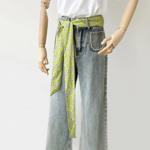 Florales Baumwoll-Seidentuch als Gürtel an hellblauer Denim-Jeans mit Perlendetails