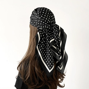 Vue arrière d'un foulard en soie porté en bandana avec des pois blancs sur fond noir