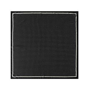 Detailed view of square silk scarf featuring black and white polka dots with sleek white edges