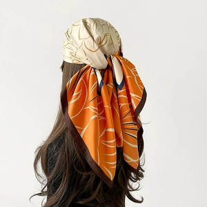 Elegante sciarpa in raso a fiori indossata come foulard arancione e blu scuro