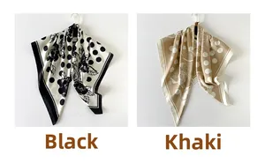 Detail of hanging silk square scarves featuring polka dots and floral patterns in black and khaki