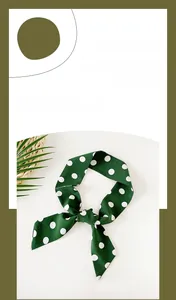 Close-up of a forest green satin ribbon scarf featuring white polka dots tied in a knot