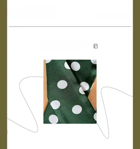 Detailed view of dark green satin fabric with white polka dots and silky glossy texture