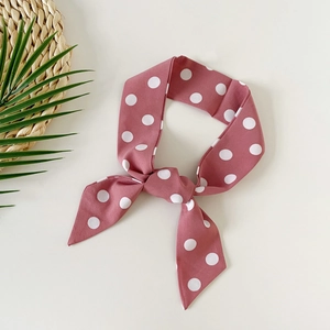Elegant dusty rose polka dot skinny silk scarf tied in a rabbit ear bow knot style