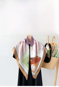 Detailed view of floral silk scarf with geometric patterns on a wooden hanger with tulips