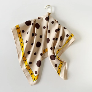 Vue détaillée d'un foulard en soie à pois marrons avec une bordure jaune élégante