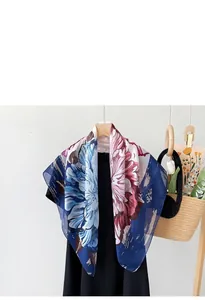 Close-up of soft floral silk scarf with elegant pink and blue peony print detail