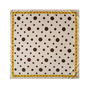 Détail d'un carré de soie avec des pois marron et une bordure jaune vif élégante