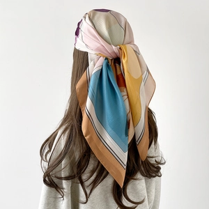 Elegant 90cm square silk scarf with multi-color geometric print worn as a headscarf