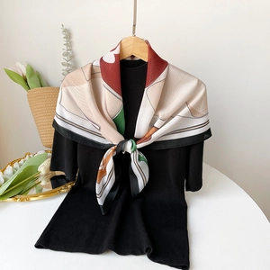Elegant geometric print silk scarf displayed with accessories and white tulips